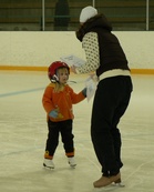 4-vuotias Heidi noutamassa diplomiaan valmentajalta.